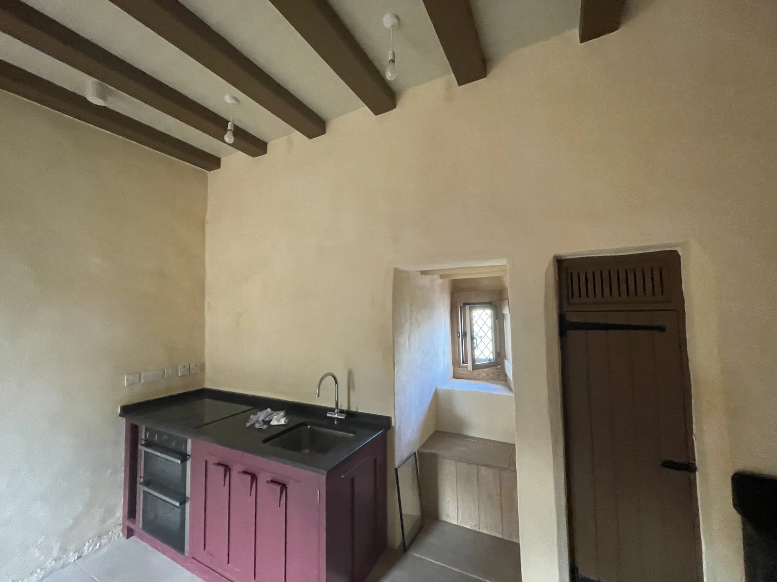 Fairburn Tower, Ross-shire: a lime plastered room in the restored tower house, with the new timber ceiling and workshop-made door