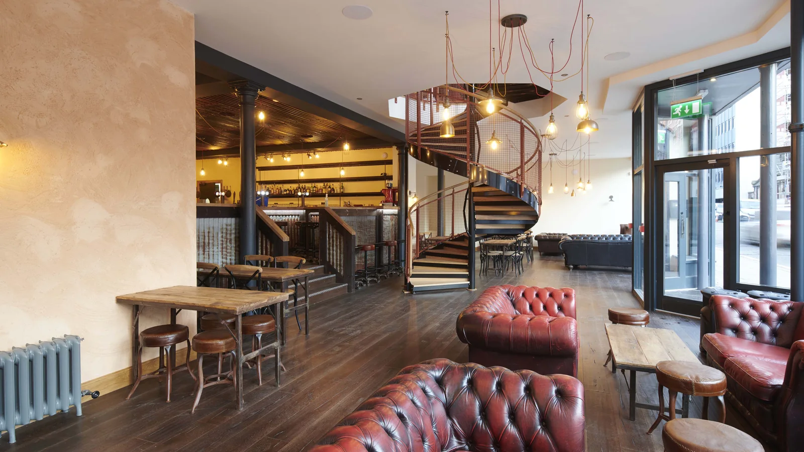 Rose Street Foundry, Inverness: the ground floor bar, with the salvaged timber, cast iron radiators and the spiral stair to the restaurant above