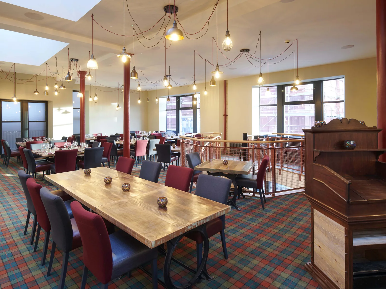 The first floor restaurant, with the cast iron columns and roof structure kept in view and the salvaged light shades and radiators reused