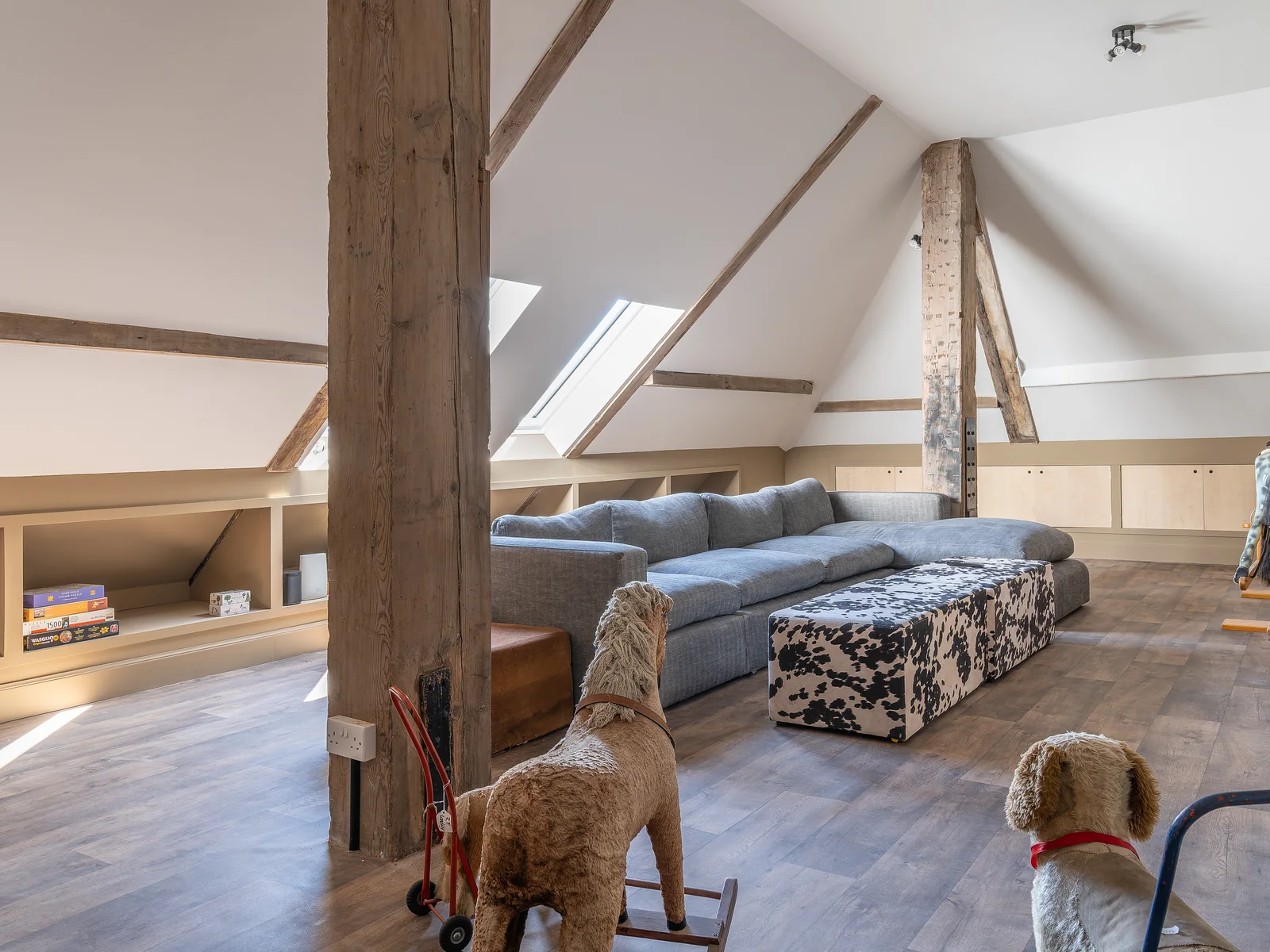 The attic room at Asknish House, with the exposed stone and roof timbers kept in view, the new rooflight and the finished oak floor