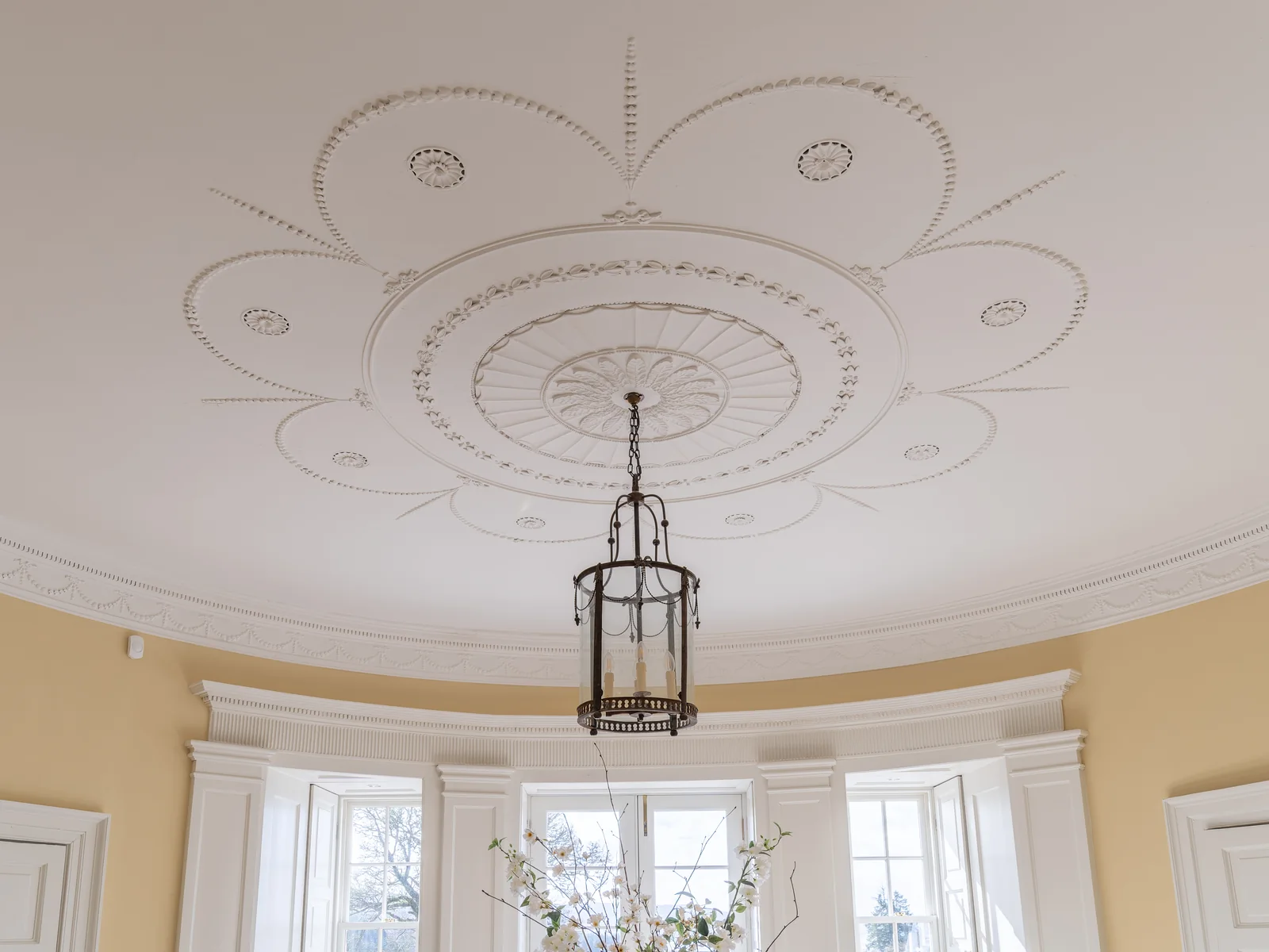 The same ceiling reinstated in the bow room: the original fragments consolidated and the missing sections cast, fitted and painted by our plasterers