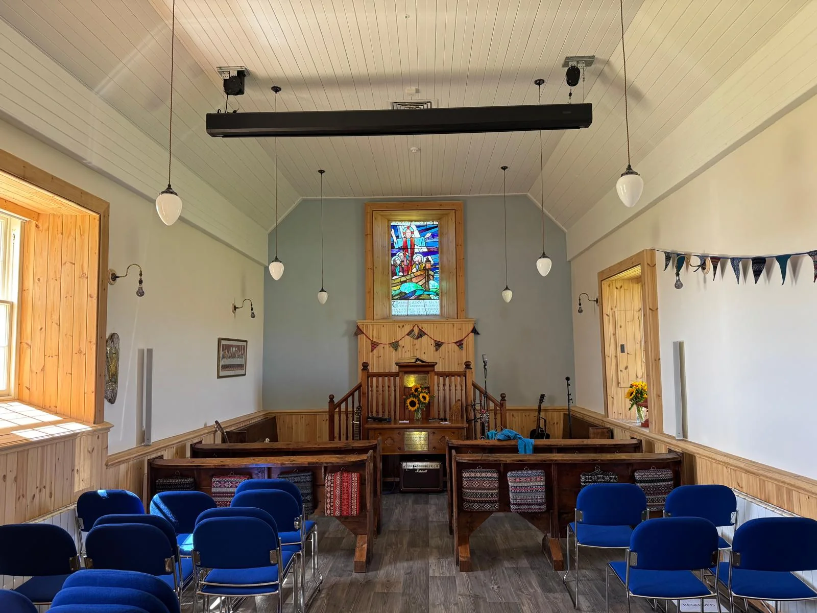 Papa Stour Kirk, Shetland: the finished nave, with insulating lime plaster walls, insulated ceiling, new lighting and the original pews adapted and reinstated