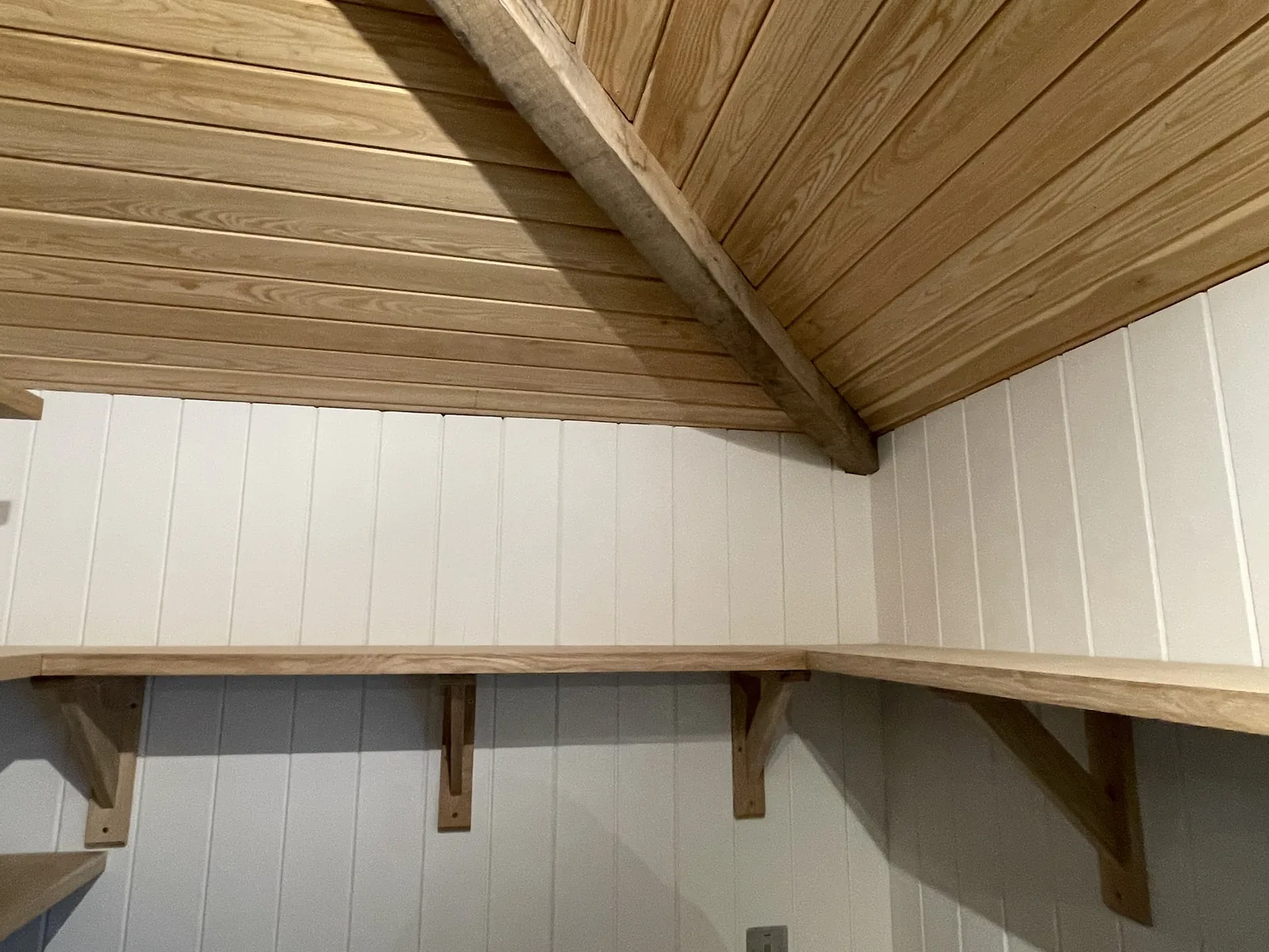 Asknish House: the pantry, with oak shelves on shaped brackets against painted tongue-and-groove lining under a boarded ceiling