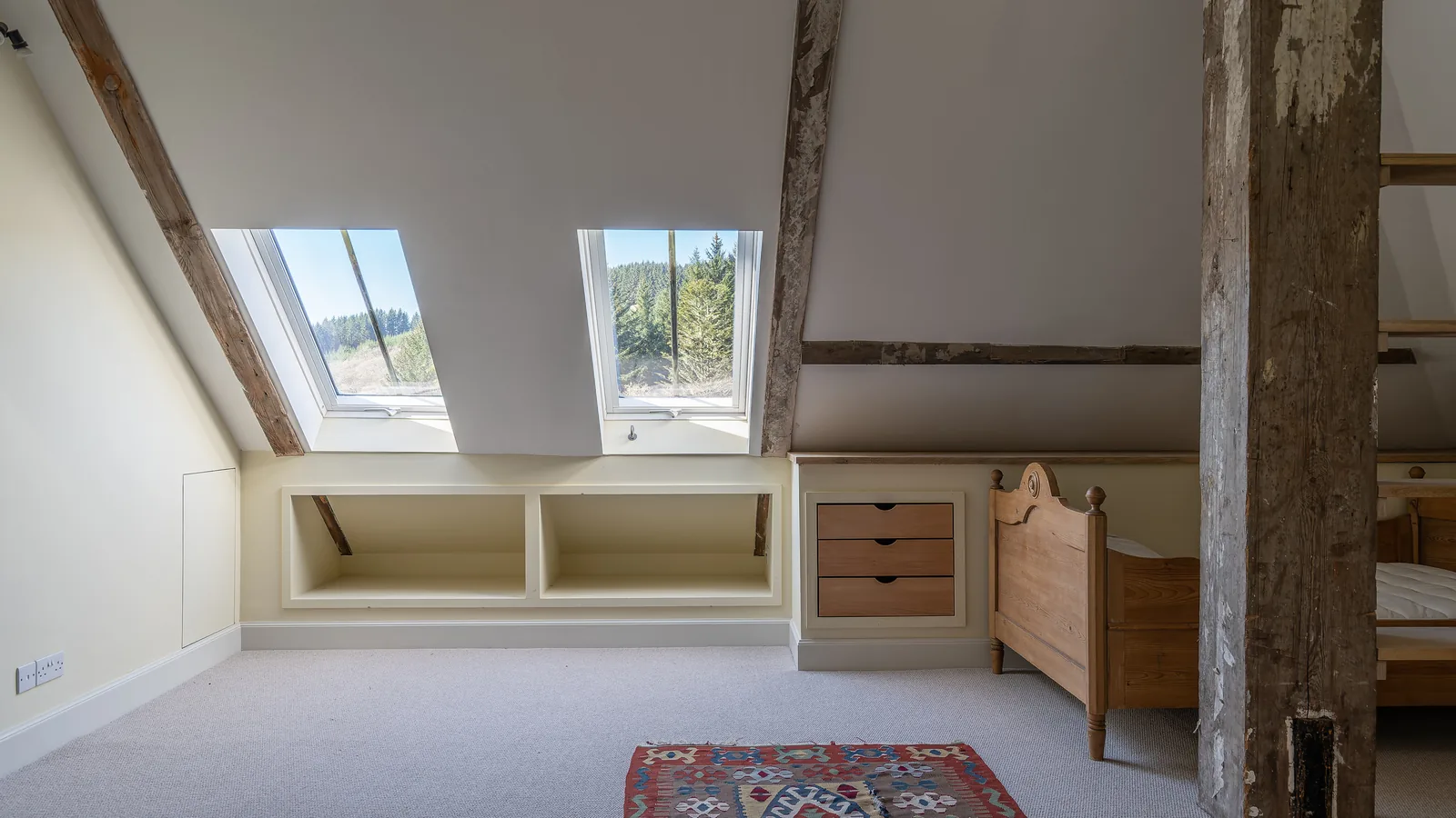 Asknish House: attic rooms with shelving and drawer units built in under the eaves among the original roof timbers