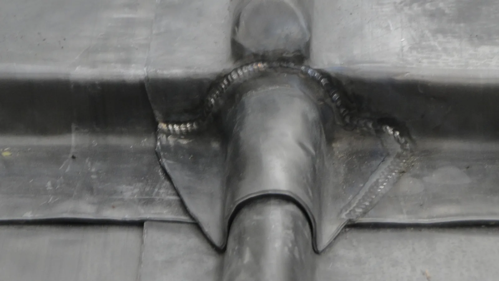 Lerwick Town Hall: a pipe penetration lead burned into the new roof, with the rolls running past it