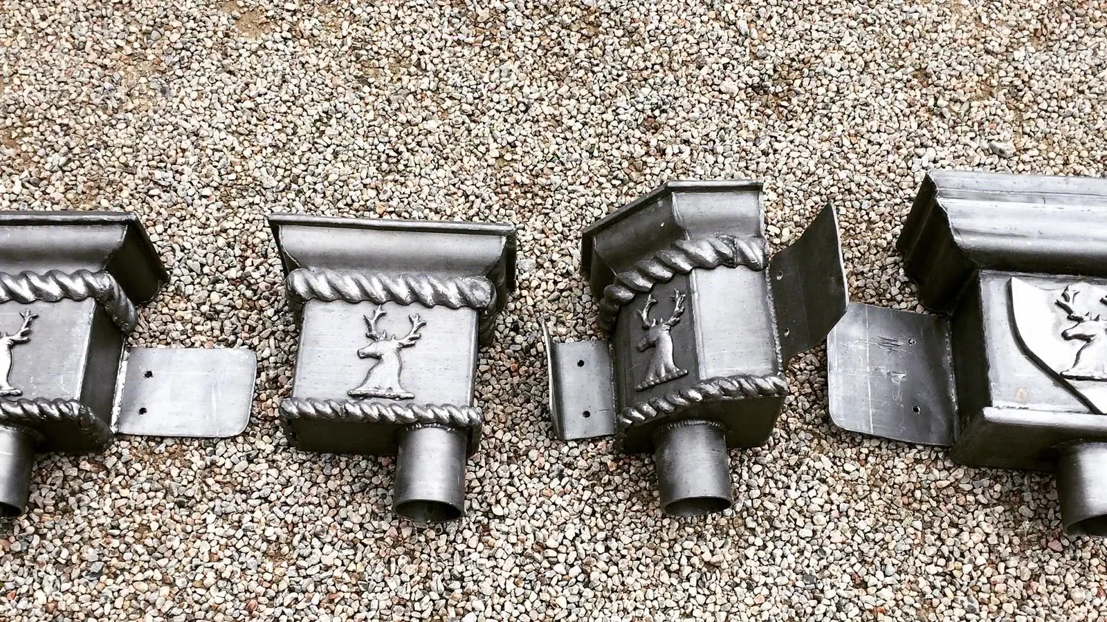 Aldourie Castle: new cast lead hoppers carrying the estate's stag crest, ready for fixing