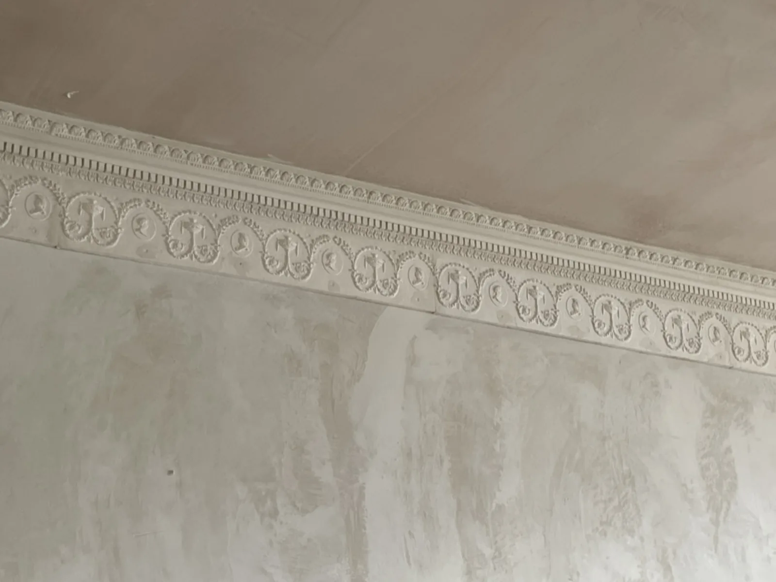 The new frieze fixed and painted, running unbroken with the original beneath the cornice