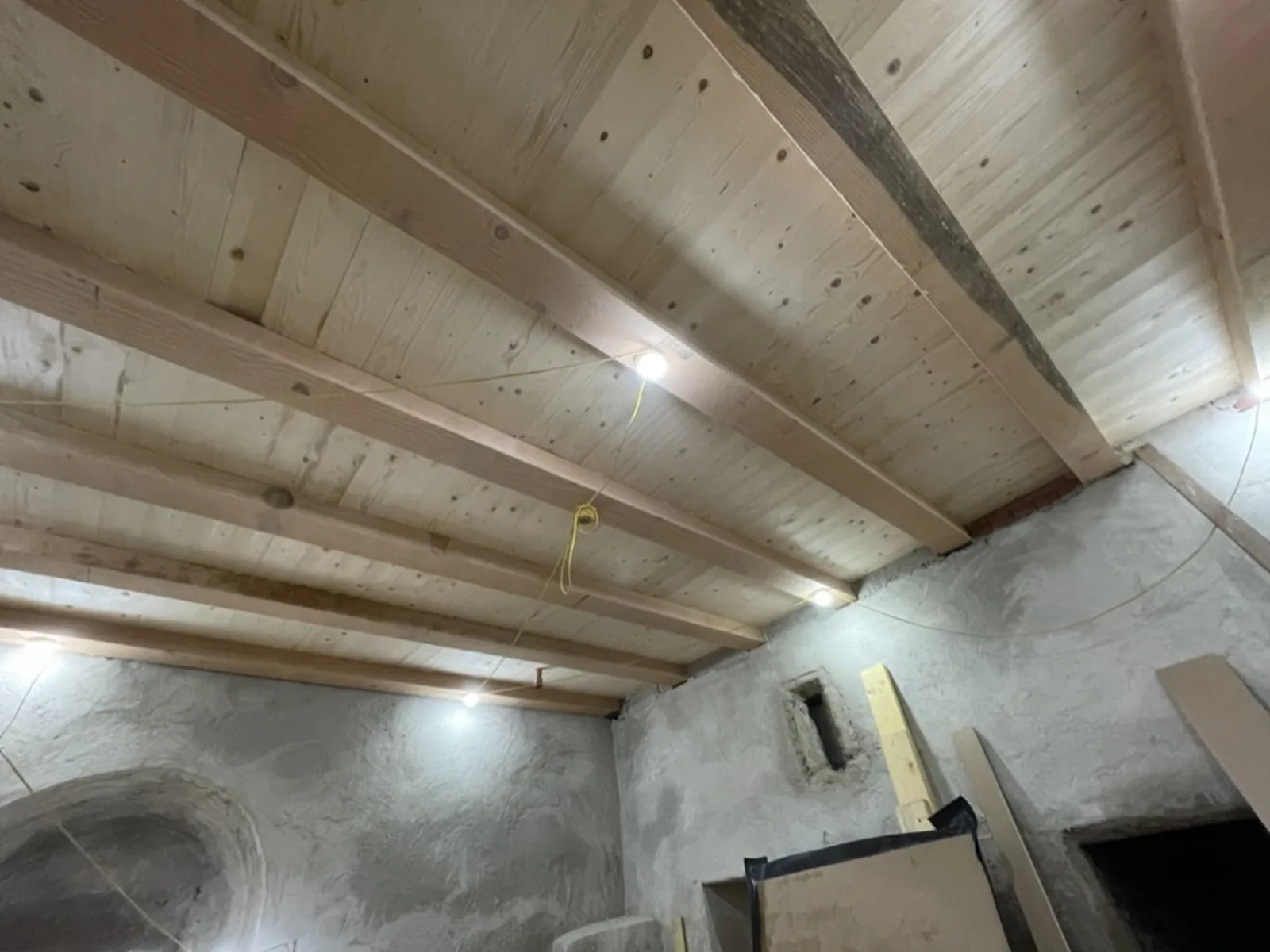 A ceiling rebuilt from the joists up: new timbers and sarking over the stripped stone walls before lathing and plastering