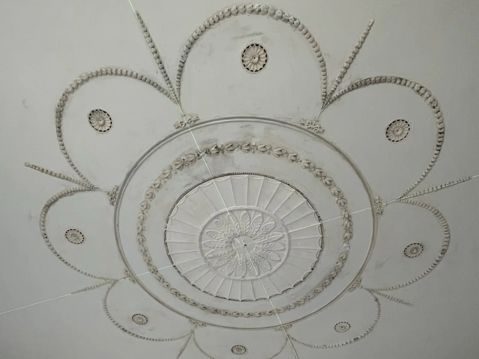 The centre of the same ceiling: the fluted rose and the chains of husks picked out in gilt