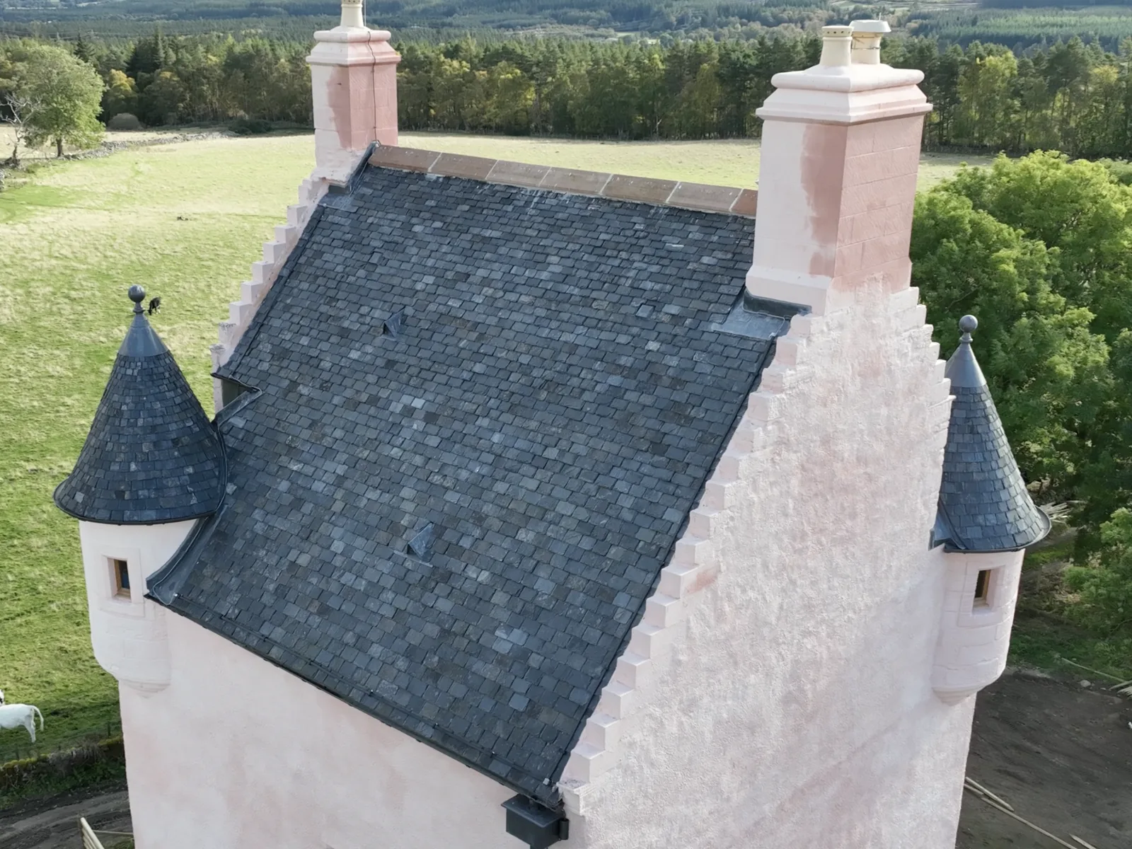 The same tower house from the air: new slating swept round the turrets and dressed in lead to the chimney heads