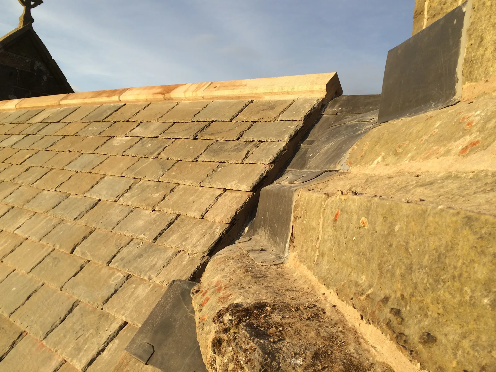 St Athernase Church: Denfind stone slates from the Pitairlie Quarry, cut and dressed to the diminishing courses of the original Carmyllie stone, against a new lead skew