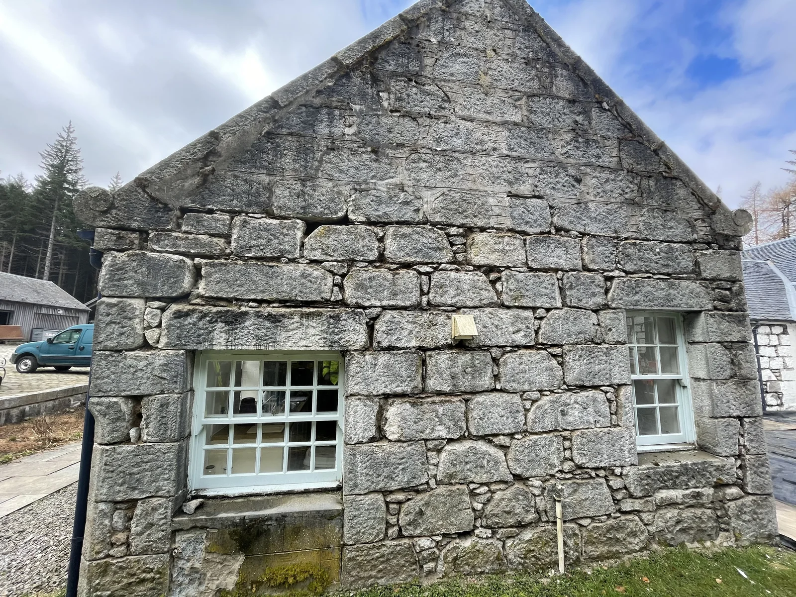 A gable stripped of paint, with the last of the coating still sitting in the cement joints before they are raked out