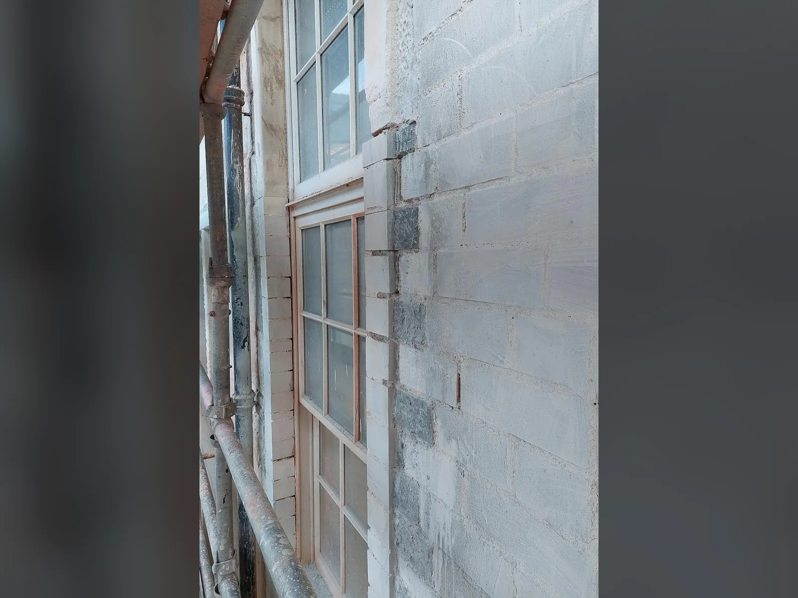 The ashlar dressed back to crisp, regular courses with sharp arrises, re-forming a formal ashlar face from the original stone