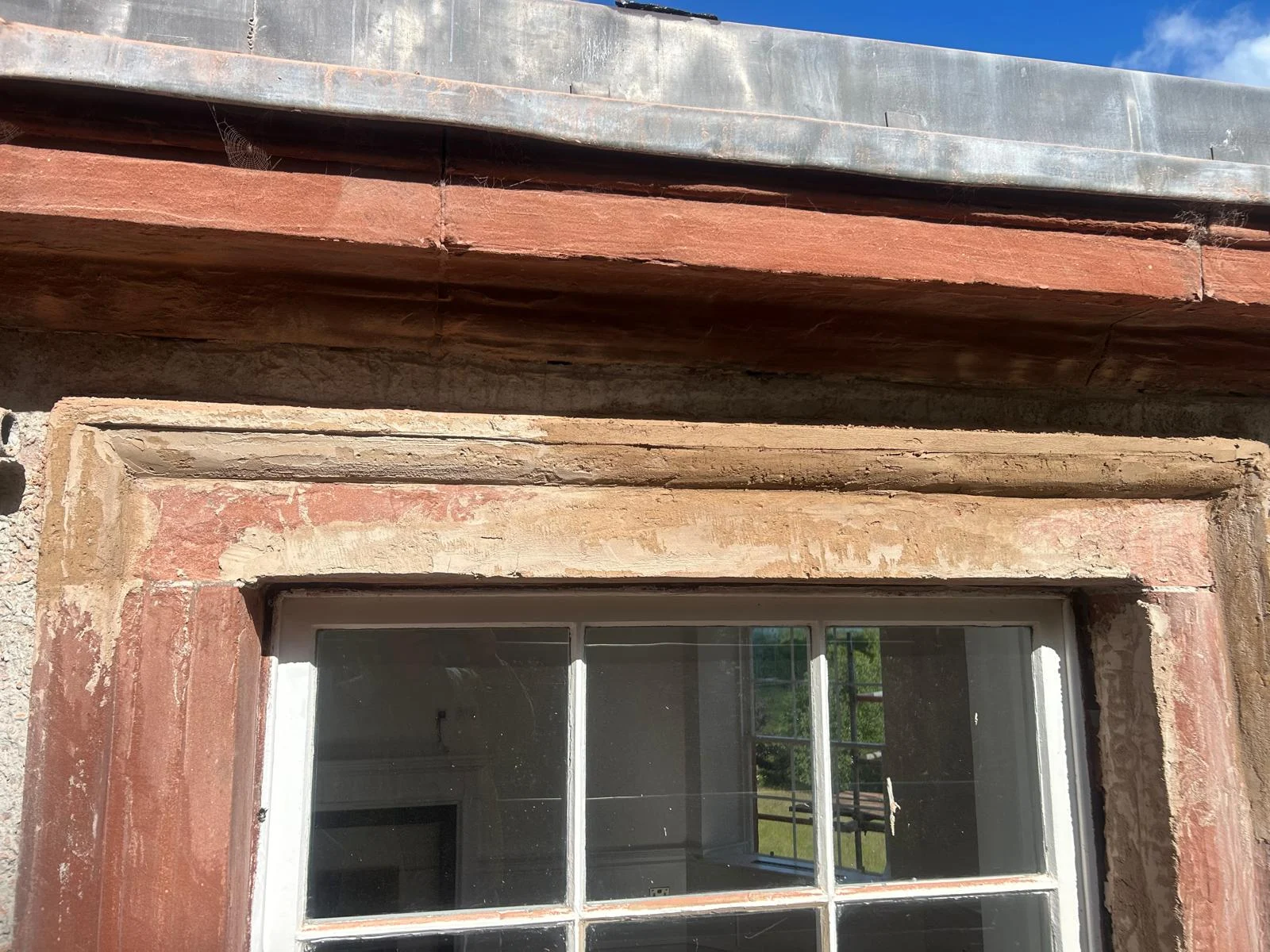 The colour-matched lime mortar built up over the armatures in layers and roughed out to the line of the moulding
