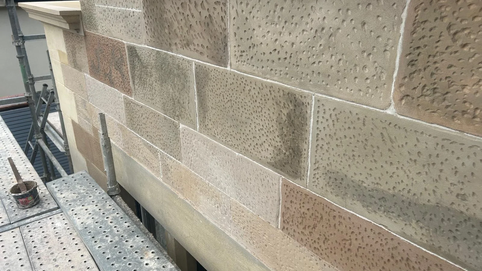 New sandstone ashlar with a punched finish, the faces toned to sit with the existing masonry