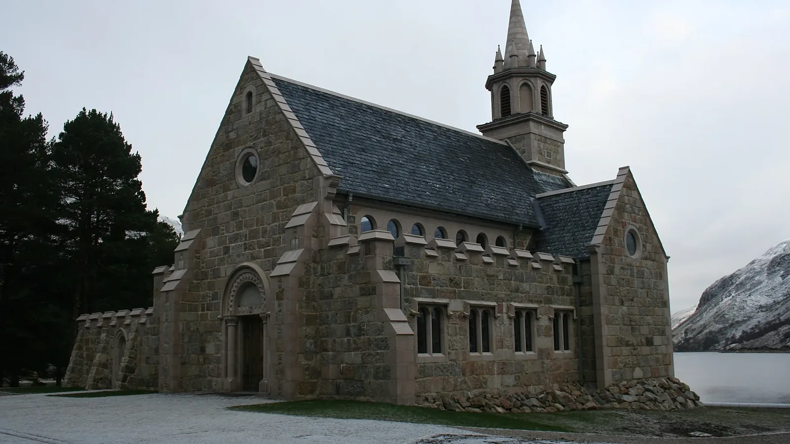 Ben Alder Chapel: a new estate chapel beside a Highland loch, its granite nave, transepts, Romanesque porch and spire built by LTM masons in lime mortar