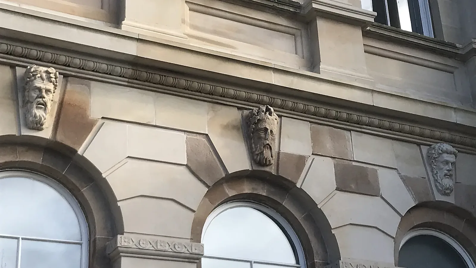 Irvine Town House: carved face masks over the arched windows of the sandstone civic building, seven of them newly carved by LTM masons from the sculpture of another building by the same architect