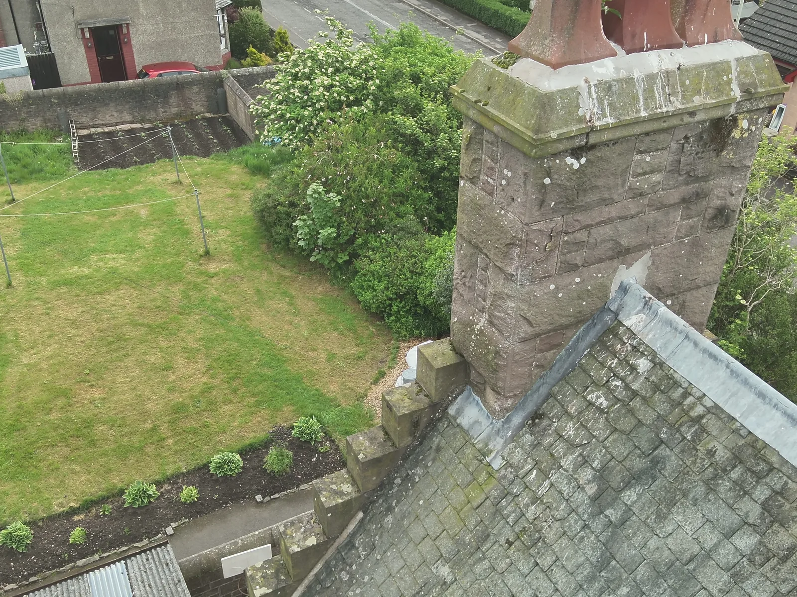A chimney stack and its pots photographed from above, cement flaunching and open joints picked out for the report