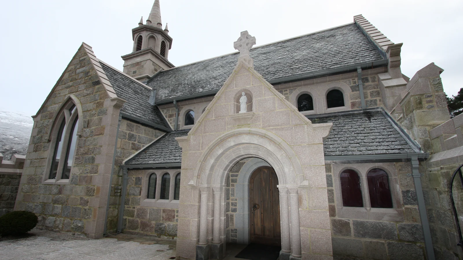 Ben Alder Chapel, near Dalwhinnie: a new estate chapel built by LTM in reclaimed granite and hot lime over a steel frame, with its Romanesque porch, spire and slated roof complete