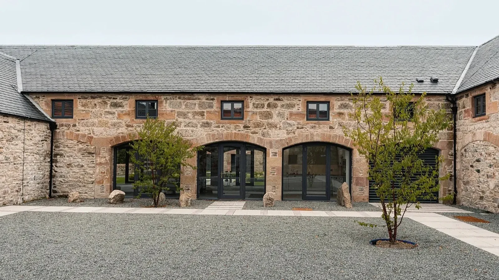 Ardross Distillery, Easter Ross: the roofless steading restored and the new still house and boiler house built in rubble salvaged from the site with Lazonby sandstone dressings, for Morrison Construction