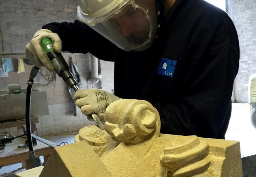 An LTM carver working a capital with a pneumatic chisel